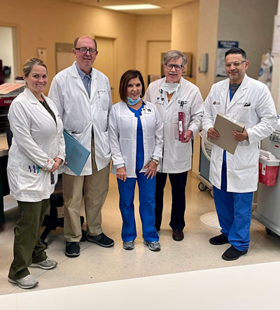 Picture of 5 doctors smiling (2 female, 3 male)
